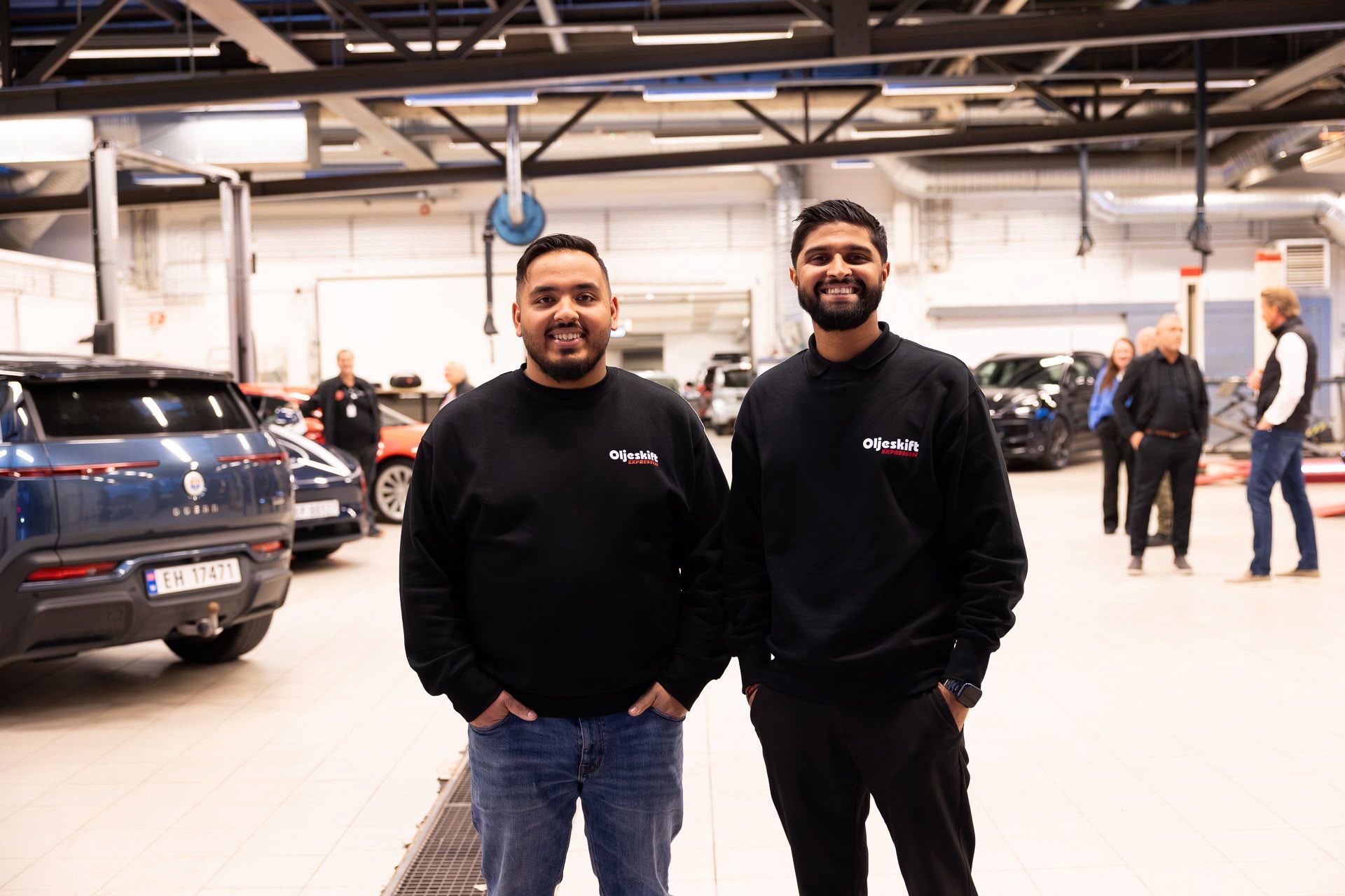 Two smiling staff members at customer reception in the workshop hall