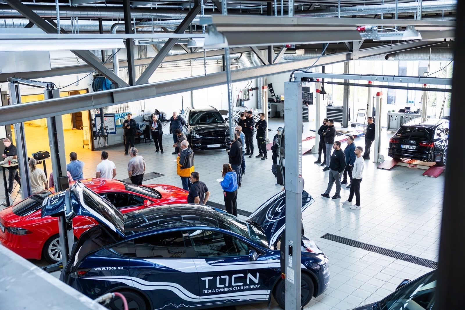 The Elbilexpressen workshop hall in Oslo seen from above, with electric cars on lifts