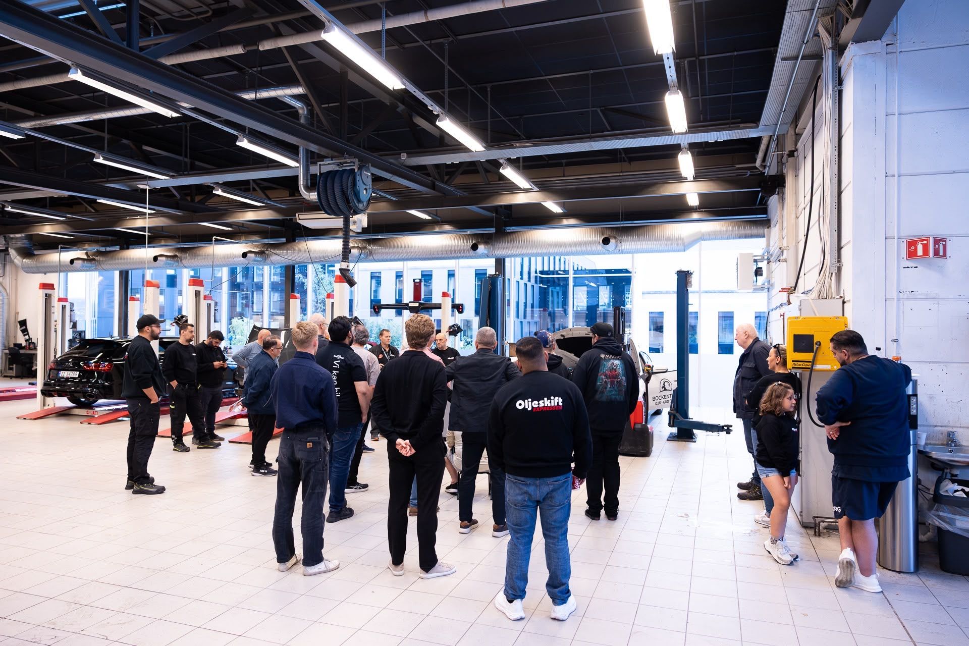 The Elbilexpressen workshop hall in Oslo with lifts, large windows and visitors